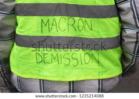 Yellow vests protest against higher fuel prices in France and text on the yellow vest president Macron departure in French