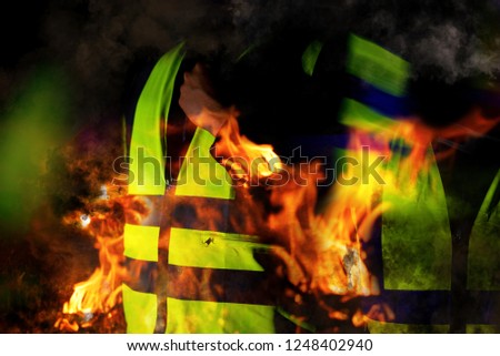 Yellow vests of protest with fire in France on black background.  Protester news concept.