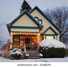 A Yellow Victorian House With Green Trim And Christmas Holiday Decorations.