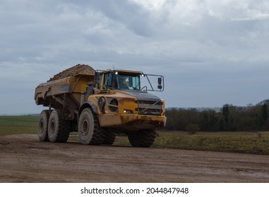 yellow Volvo A40E articulated dump truck earth mover with 25 tonne payload driving across Salisbury Plain, Wiltshire UK