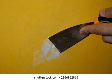 The Yellow Wall Putty Process. Metal Spatula In Hand 