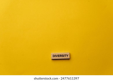 yellow warm background without shadows wooden cubes with black letters laid out word diversity