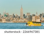 Yellow water taxi to West Side of  Midtown Manhattan across Hudson river at sunset, New York city, USA