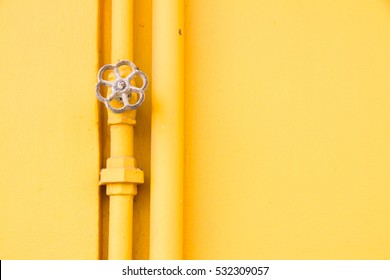 Yellow Water Valve On Yellow Wall.