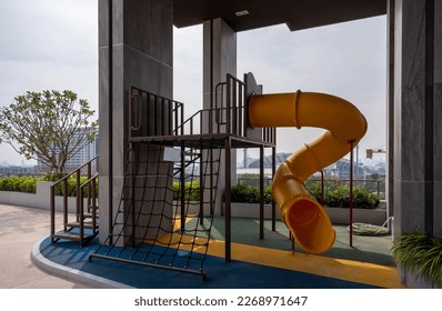 yellow wavy playground slide at condominium rooftop