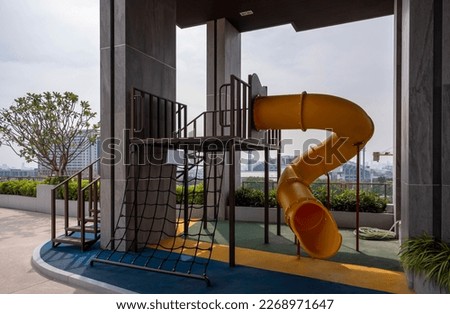 yellow wavy playground slide at condominium rooftop