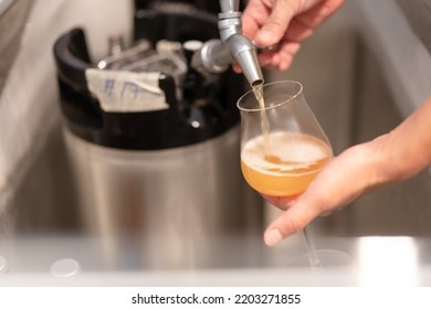 Yellow Weizen Beer Pouring From Home Brew Keg Through Silver Dispenser To Chill Glass