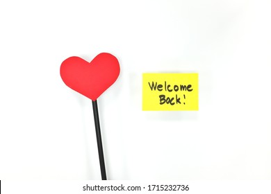 Yellow welcome back card note with a red heart. Back to office, work and school concept.