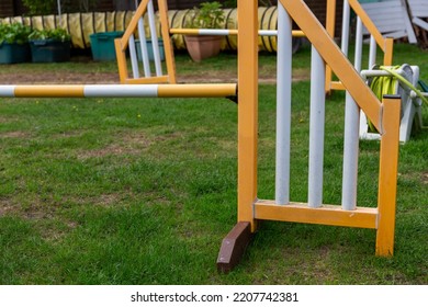 Yellow And White Hurdle For Canine And Dog Agility In A Suburban Garden With Other Hurdles Behind