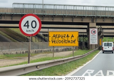 Yellow and white Speed limit Traffic signs on a highway. Translation: 40 kilometers per hour, Reduce speed, Trucks and  buses mandatory on the right lane 