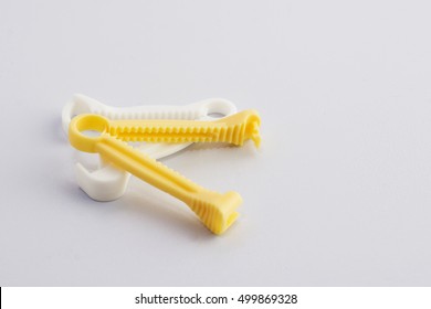 Yellow And White Umbilical Cord Clamp Used To Clamp Off The Umbilical Cord After A Baby's Birth.