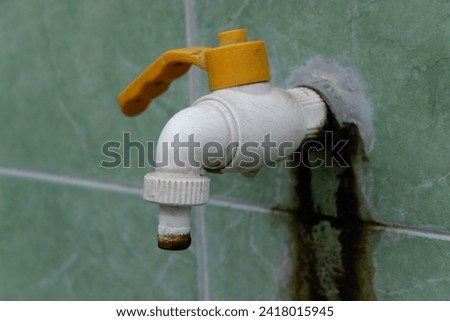 The yellow and white water tap installed in the mosque functions for ablution before prayer.