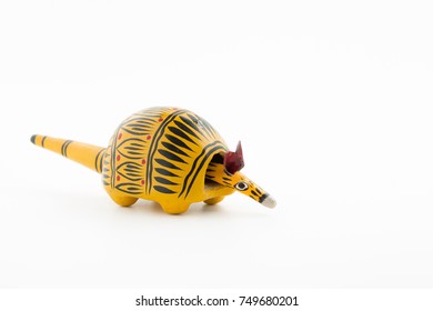 Yellow Wooden Armadillo Toy With Black Sign And Bobble Head On White Background