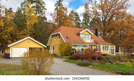 Yellow wooden house. Glassed terrace. Colorful wooden house. Fall season landscape. Sweden countryside in autumn. View of beautiful  European garden design. Golden, yellow, brown, red colors of leaves - Powered by Shutterstock