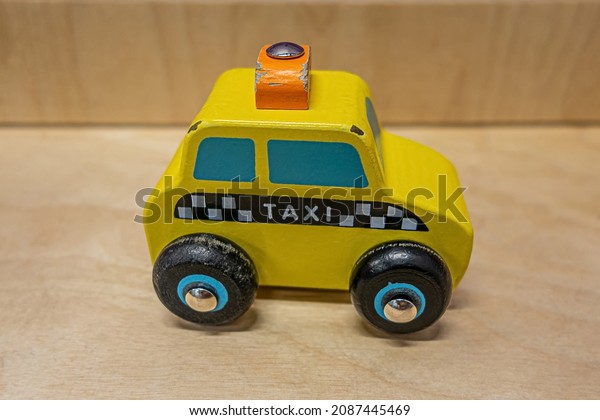Yellow\
wooden old taxi car toy with lettering\
TAXI.