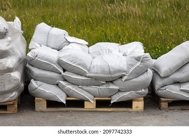 Yellow wooden Pallets with white sandbags are outside for building in summer
