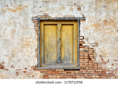 Yellow wooden window with crack brick wall texture background