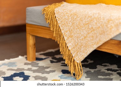 Yellow Wool Blanket Lying On A Grey Sofa. Soft Cashmere Fabric Blanket With Fringe. Autumn - Winter Concept Of  Comfort And Cozy Home.