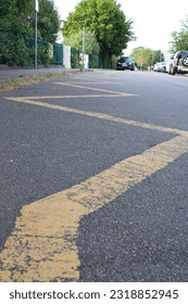 Yellow Zig Zag lines indicating to motorists to keep clear no parking taken outside school entrance UK