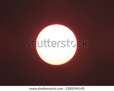 yellowish sun, with its perfect circular shape, in the darkened sky due to its luminosity