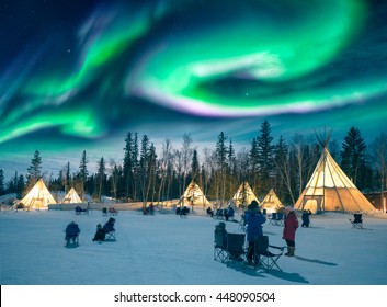 Yellowknife, Canada - March 17 2016 : Amazing northern lights dancing over the tepees at Aurora Village in Yellowknife.