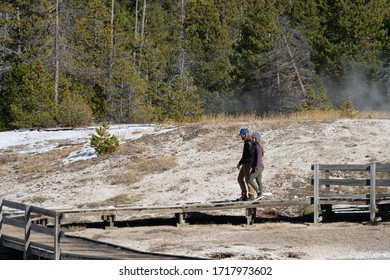 Yellowstone National Park, Wyoming/USA - October 12, 2019: Couple Walking Along Boardwalk In Yellowstone Near Old Faithful.