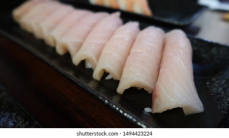 Yellowtail Nigiri Sushi Over Rice On Long Black Plate