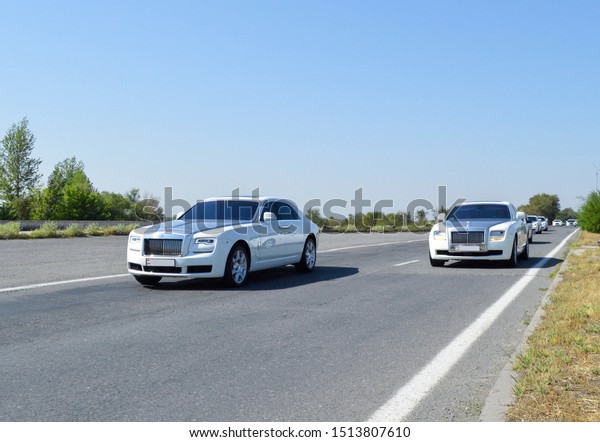 Yerevan, Armenia - 23 September\
2019.\
Different luxury cars on the highway. You can see driving\
through different Rolls-Royce\'s and Bentley\'s on the highway with\
green trees a on the\
background.