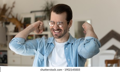 Yes I can. Excited young man raising up fists with joy delight feeling euphoria proud of victory reaching goal. Happy male winner celebrating success or personal achievement get dream wish come true - Shutterstock ID 1902145003