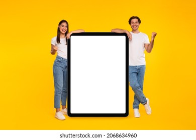 Yes. Excited Couple Leaning On Big Tablet With Empty White Screen Shaking Clenched Fists, Cheerful Guy And Lady Celebrating Win, Standing On Yellow Orange Background, Mock Up Collage, Full Body Length - Powered by Shutterstock