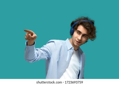 Yes man. Portrait of a young beautiful man wearing white t-shirt and blue shirt in headphones point to agree with somebody by his forefinger - Shutterstock ID 1723693759