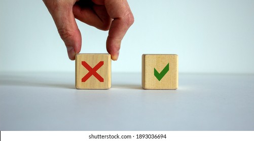 Yes or no choice symbol. Hand making a choice between two cubes with Yes and No icon on beautiful neutral white background. Business and yes or no choice concept. Copy space.