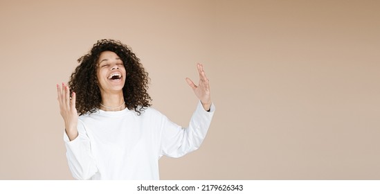 Yes! Pretty Extremely Happy African American Woman Celebrating Her Success With Raised Hands End Yelling Loud Glad Isolated Beige Background                               