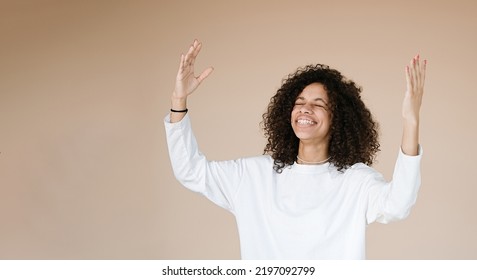 Yes! Pretty Extremely Happy African American Woman Celebrating Her Success With Raised Hands End Yelling Loud Glad Isolated Beige Background	                               