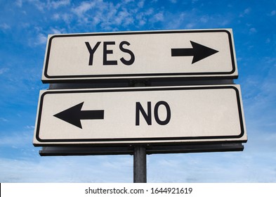 Yes Vs No. White Two Street Signs With Arrow On Metal Pole With Word. Directional Road. Crossroads Road Sign, Two Arrow. Blue Sky Background. Two Way Road Sign With Text.