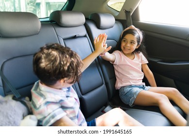 Yes, We Did It! Hispanic Little Sister And Brother Doing A High Five In The Car After Their Parents Agreed To Take Them To The Park To Play