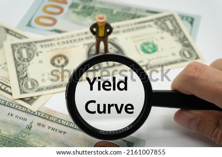 Yield Curve.Magnifying glass showing the words.Background of banknotes and coins.basic concepts of finance.Business theme.Financial terms.