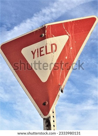 A YIELD sign is bent and cracked as if someone didn't yield.