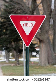 Yield street sign in a city, red triangle traffic roadsign