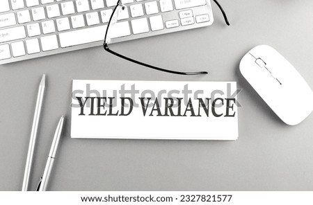 YIELD VARIANCE text on a paper with keyboard on grey background