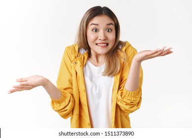 Yikes sorry not knew. Awkward cheerful blond asian woman shrugging hands spread sideways unaware questioned perplexed answer clench teeth uncertain expression clueless say, white background