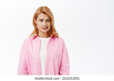 Yikes, Thats Awful. Young Woman Grimaces From Cringe And Disgusting Emotion, Looking With Aversion At Camera, Dislike Face, Standing Over White Background