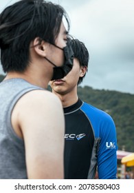 YILAN, TAIWAN - Oct 20, 2021: A Vertical Portrait Of A Man In A Wet Suit With Another Man In A Mask In The Foreground In Taiwan