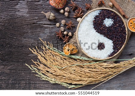 Yin Yang sign with black rice and jasmine white rice  on wooden background. Concept healthy eating,organic food
