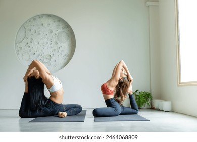 yoga, Asian woman wearing yoga clothes practicing yoga, Asia group of women exercising healthy lifestyle in fitness studio. Sport activity, gymnastics or ballet dancing class. - Powered by Shutterstock