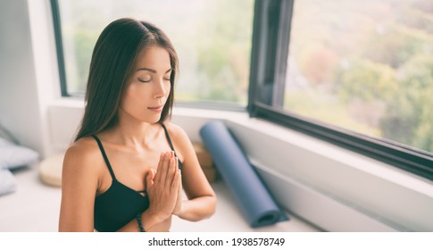 Yoga class meditation. Asian woman meditating zen for stress free day at home or gym. Panoramic banner of girl with closed eyes and palms together in prayer pose for mindfulness.