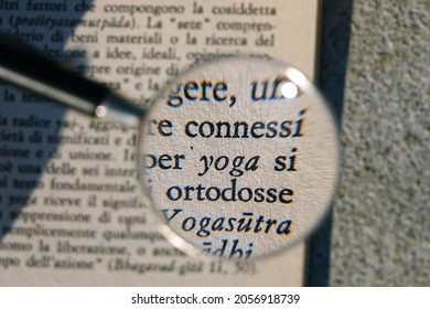 Yoga concept: words from a book written in Italian enlarged by a magnifying glass