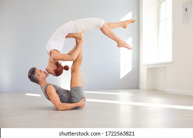 Yoga couple practice acro yoga on the floor in a studio class. - Powered by Shutterstock