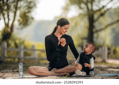 Yoga day, sitting. Mother with her little son is outdoors. In sportive clothes. - Powered by Shutterstock