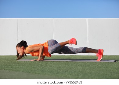 Yoga Fitness Girl Training Triceps Doing Advanced Push-up Chaturanga With Leg Side Crunch Spiderman Pose. Pushup Exercise Variation Workout Asian Woman On Exercise Mat Outdoors. Happy Active Person.